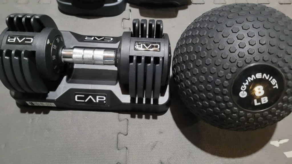 The Cap Barbell adjustable dumbbells next to my small slam ball